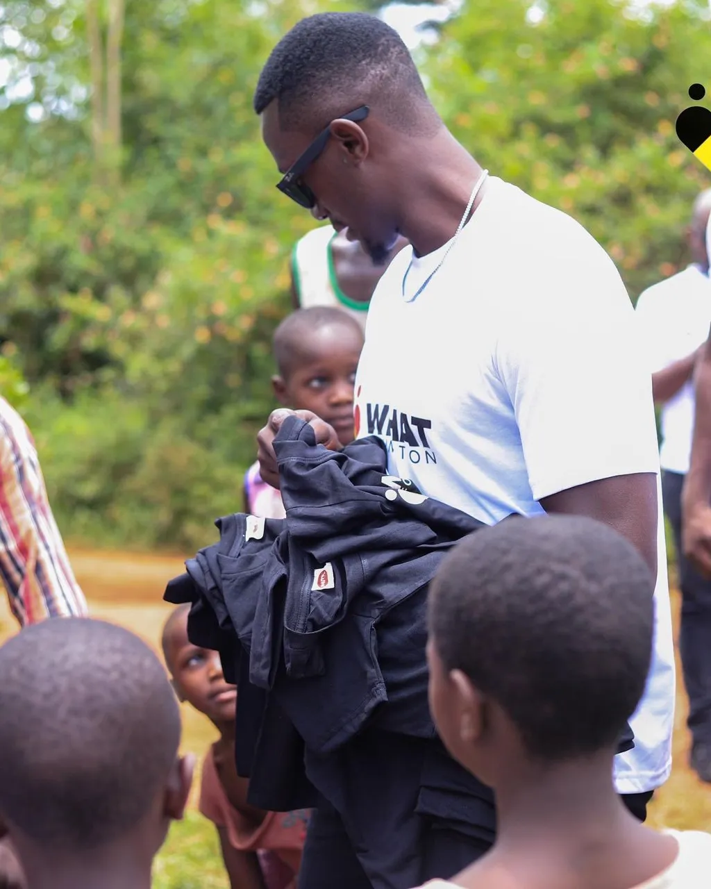 WEHAT Foundation Uganda NGO giving black shirts to community members